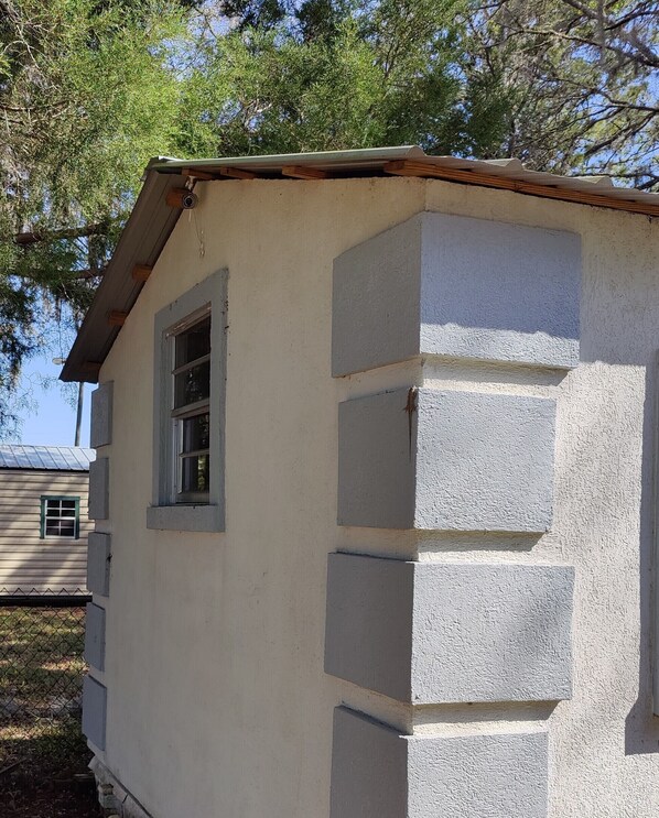A small, single-story building with a white exterior and a window on the left side. - Suwannee Riverfront Retreat (Old Town)