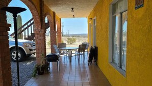 A covered outdoor area with a brick archway, a table with chairs, and a car parked outside. - PRIVATE, COMFORTABLE & SPACIOUS! NEAR THE  MARINA, BEACHES & DOWNTOWN! CONDO 302 (San Felípe)