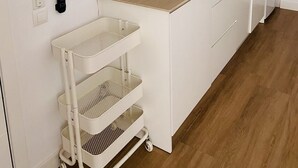 Una cucina moderna con mobili bianchi, un lavello in acciaio inossidabile, un forno a microonde e un forno integrato.