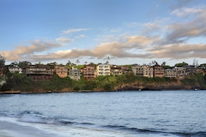 Uma área residencial costeira com edifícios altos, alguns com varandas, de frente para a água.