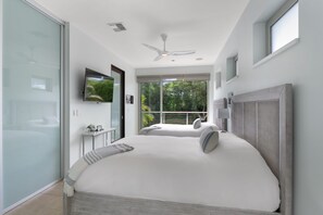 Relax in this serene bedroom with a large bed, ceiling fan, and flat-screen TV.