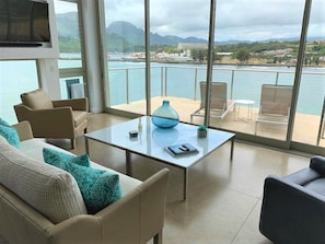 Relax in a serene space with expansive views of a body of water and distant mountains.