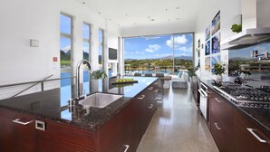 Una cocina moderna con una isla grande, electrodomésticos de acero inoxidable y vistas a un paisaje montañoso.