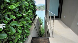Una scala con ringhiera in metallo conduce a un balcone con vista sull'acqua.