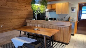 A modern kitchen with wooden cabinets, a central island, and a hanging plant. - Waterfront A-Frame on the Marina • Lake Pepin (Pepin)