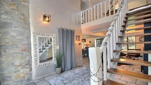 Un escalier avec des marches en bois et une rampe blanche, menant à un niveau supérieur.