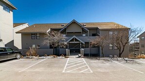 A building with a central entrance, a parking lot, and a tree in front. - Cozy Condo with Table Rock Lake Views, Free Tickets & 5 Minutes from Silver Dollar City (Branson)