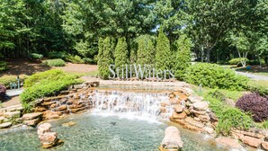 Uma cascata em um parque, com uma placa que diz 'Stillwaters'.