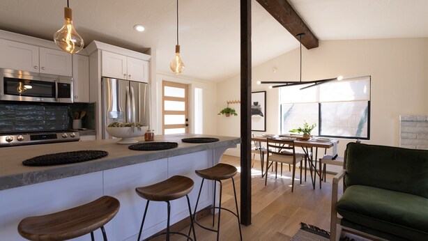 A modern kitchen with a central island, bar stools, and a dining area with a table and chairs. - Designer Bungalow in Heart of Sedona, Enclosed Yard/Patio, Luxe Kitchen (Sedona)