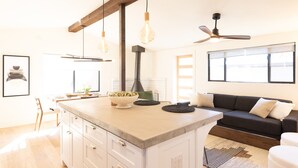 A kitchen with a central island, wooden beams, pendant lights, and a ceiling fan. - Designer Bungalow in Heart of Sedona, Enclosed Yard/Patio, Luxe Kitchen (Sedona)
