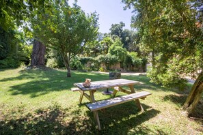 A picnic table in a grassy area surrounded by trees.