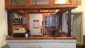 A bar area with a wooden counter, two stools, a coffee machine, and a wine cooler. - Bel Reve Hotel (Blackpool)