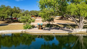 Una propiedad junto al lago con una cabaña de madera, una mesa de picnic y un soporte para canoa.