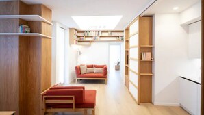 Ein modernes Interieur mit einer Couch, einer Bank, Holzregalen und einem Oberlicht.