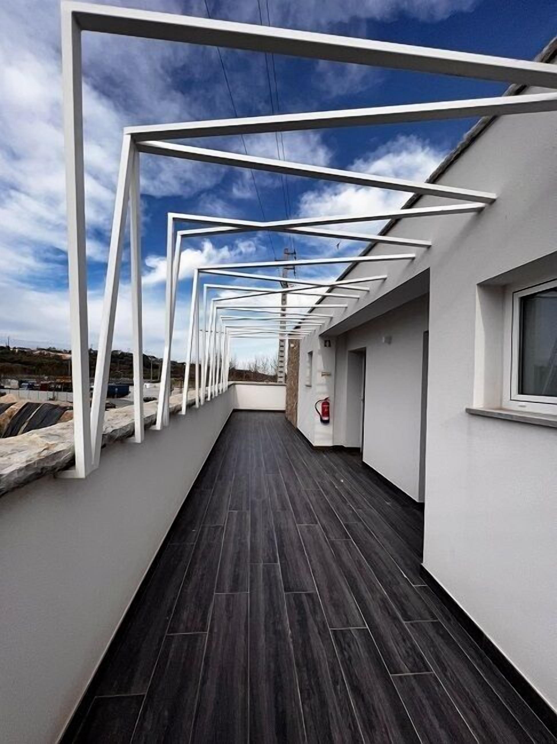 A modern building with a covered walkway and a fire extinguisher visible.