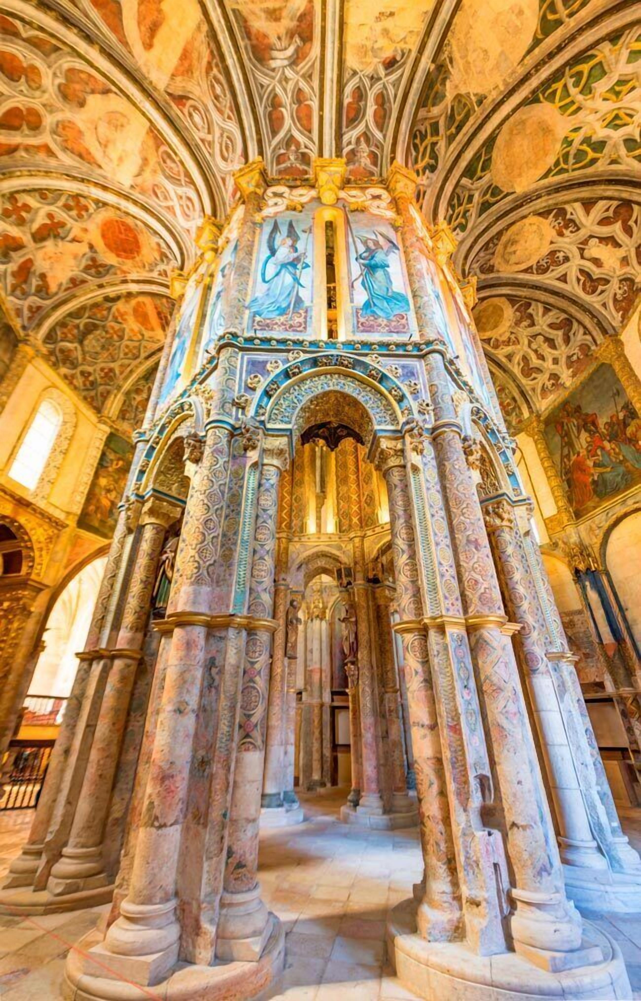 Un interior arquitectónico ornamentado con detalladas esculturas y una estructura central de columnas.