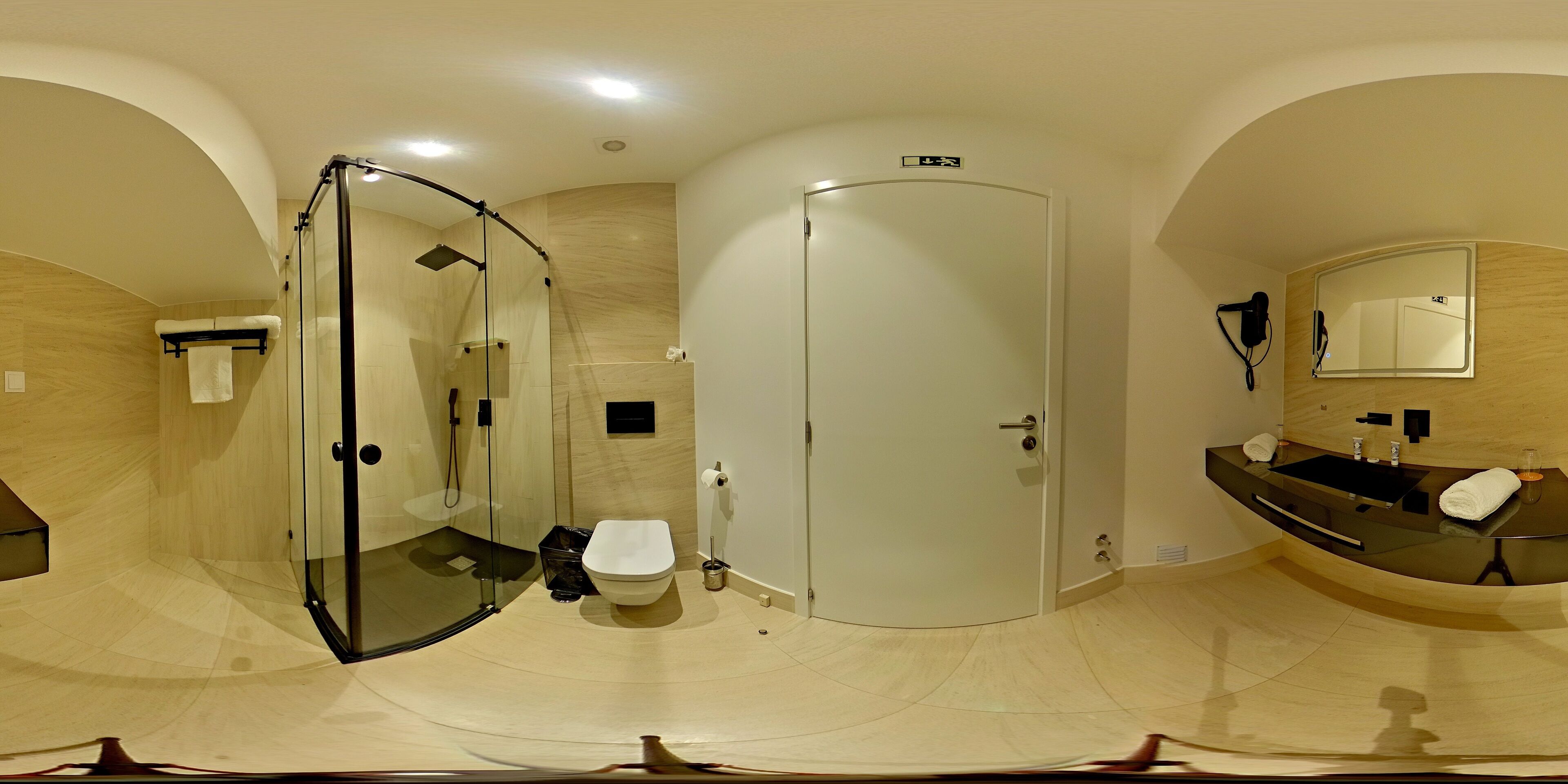 A modern bathroom with a glass-enclosed shower, a toilet, and a vanity with a mirror.