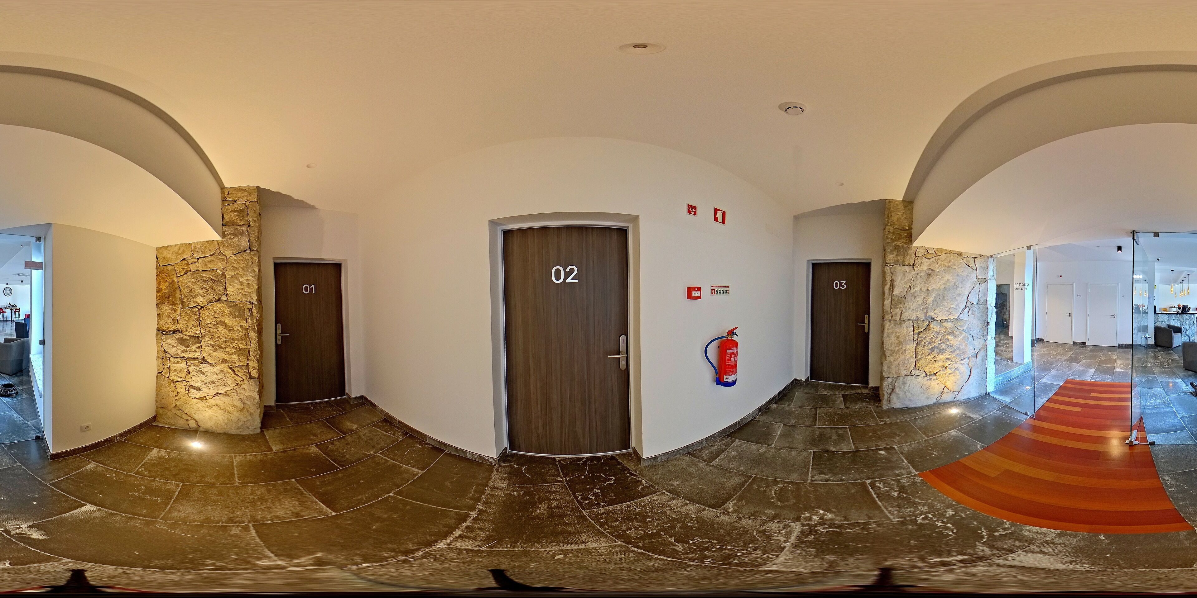 A hallway with three doors, numbered 01, 02, and 03, and a fire extinguisher on the wall.