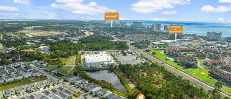 Vue aérienne d’un quartier résidentiel avec un grand bâtiment portant l’inscription « WALMART » et un autre portant l’inscription « SHOPPES AT EDGEWATER ».