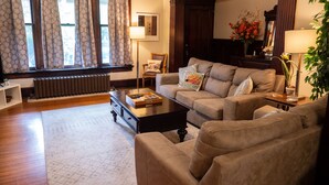 A living room with a sofa, coffee table, and a radiator. - The Kentucky Rose - Old Louisville with deck and courtyard (Louisville)