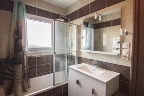 Bathtub, hair dryer, towels, toilet paper