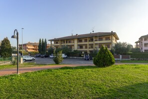 A multi-story building with a parking lot in front.