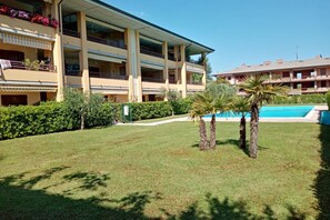 A hotel with a pool, multiple balconies, and a well-maintained lawn. - Sunflower Apartment - 2 bedrooms with pool, air conditioned and Wifi (Sirmione)