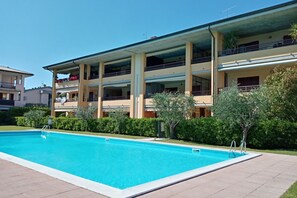 A two-story building with a swimming pool in front.