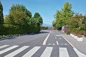 Una carretera con carril bici, paso de peatones y áreas verdes a ambos lados.