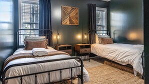 A bedroom with two beds, a ceiling fan, and a wall-mounted light fixture. - Isle of the Pines, 1 mile from The Village of Pinehurst! (Pinehurst)