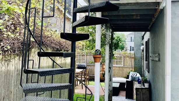 A spiral staircase leading to an upper level, surrounded by a wooden fence and a gravel path. - Private unique home short 5 minutes walk to the beach and the bay. (Hull)