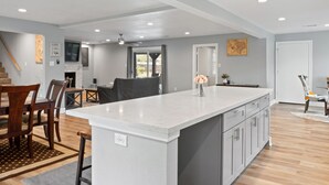 Una cocina amplia con una isla grande, mesa de comedor de madera y sillas.