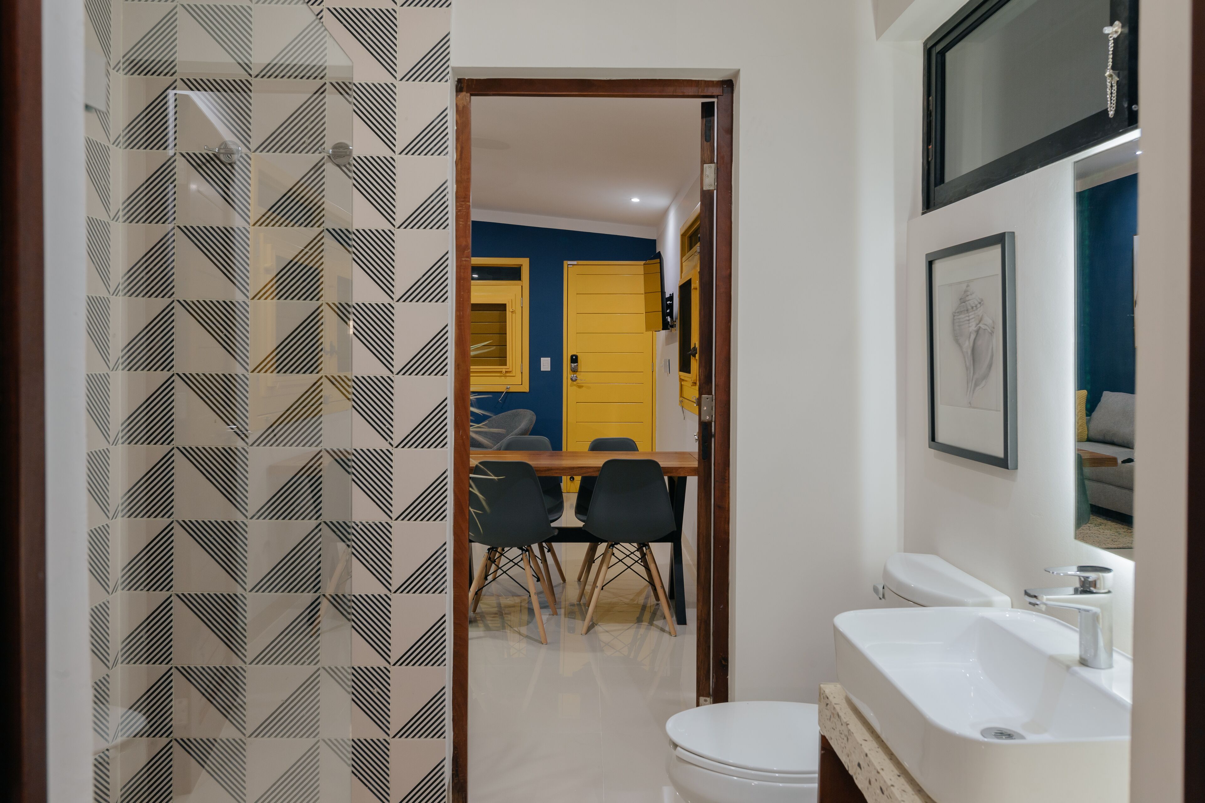 A bathroom with a white sink, a toilet, and a shower area.
