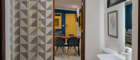 Un baño con lavamanos blanco, inodoro y zona de ducha.