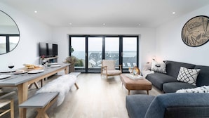 Un salon moderne avec un coin repas, de grandes fenêtres et une vue sur la ville.
