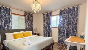 A bedroom with a large bed, a desk, and a chandelier. - Escape to the Lake! Walk to water & local dining! (Lake Geneva)