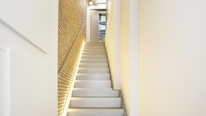 Eine Treppe mit weißen Stufen und einer Wand mit Struktur an der Seite.