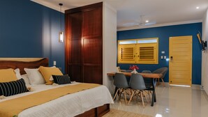 A bedroom with a bed, bedside table, and a desk with chairs. - Mare Lindo studio near Malecon Progreso (Progreso)