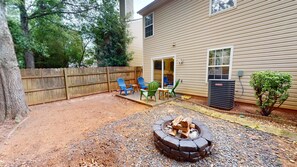 A backyard with a fire pit, outdoor chairs, and a wooden fence. - Modern Gathering House - Fire Pit - Ice Coffee - Near Atlanta - Sleeps 8 (Covington)