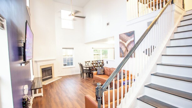 A spacious living area with a fireplace, a dining table, and a staircase.
