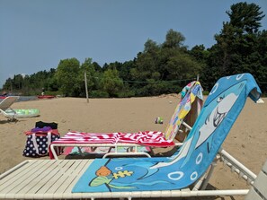 A beach chair with a shark design, a polka dot bag, and a striped towel. - A Perfect lake front Cottage (Kalkaska)