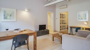 En moderne stue med et træspisebord, en sofa, et fjernsyn og kunst på væggene.