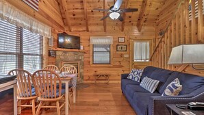 A wooden cabin interior with a dining area, a sofa, and a ceiling fan. - Cozy `American Dream` Cabin w/ Hot Tub, Loft & BBQ!!! (Cosby)