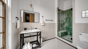 Une salle de bain moderne avec un lavabo blanc, un meuble-lavabo noir et une douche à parois de verre.