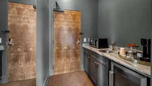 Une cuisine moderne avec des murs gris, une porte en bois et un plan de travail en marbre.