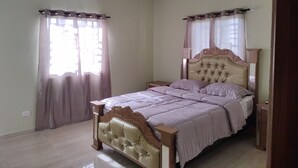A bedroom with a bed, curtains, an air conditioning unit, and a tiled floor. - Spacious and unique house closed to beaches & natural monuments! (Cabrera)