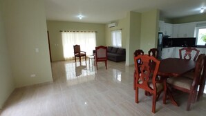 A spacious living area with a dining table and chairs, a sofa, and a kitchen area. - Spacious and unique house closed to beaches & natural monuments! (Cabrera)