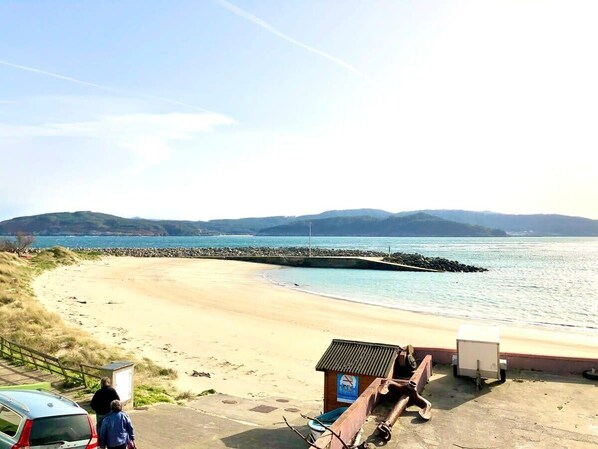 Une plage avec une structure en bois et une voiture garée à proximité.