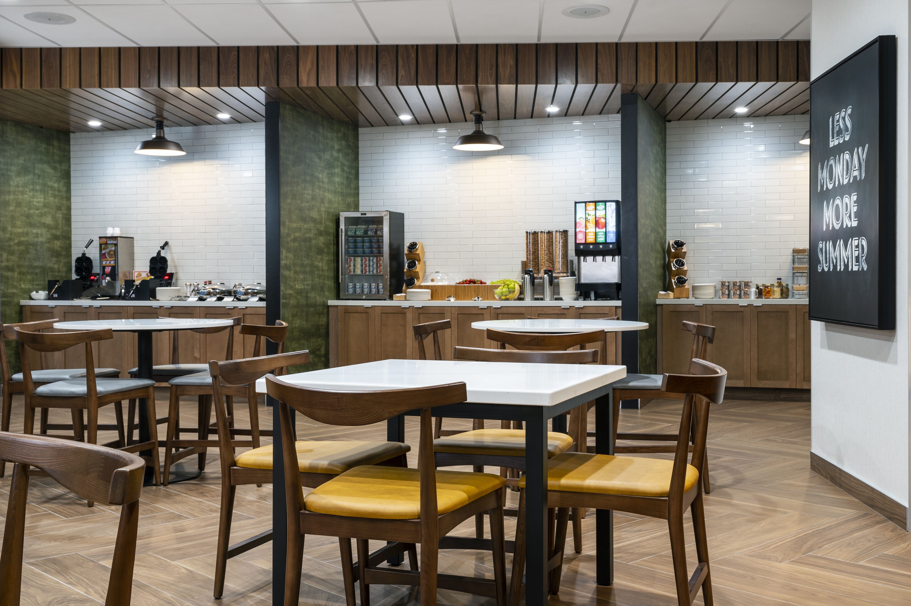 A modern restaurant interior with wooden tables and chairs, a vending machine, and a menu board.