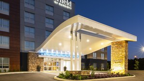 Un hotel Marriott Fairfield con una entrada moderna, un área exterior cubierta y un pilar de piedra.